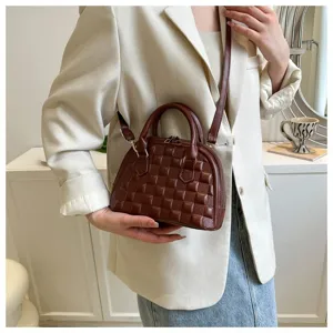 Bolso concha marrón texturizado con patrón de cuadros llevado por una modelo en blazer.