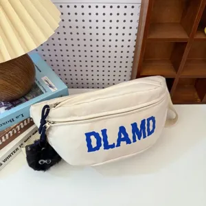 Detailed macro view of white nylon waist bag featuring blue DLAMD text and a cute black charm