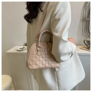 Elegante bolso de mano beige en forma de conchiglia con textura de rejilla detallado.