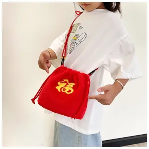 Detail view of a cute red plush drawstring bag with Fu embroidery for girls