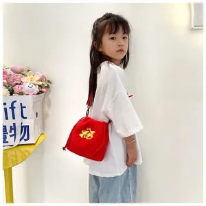 Red plush fortune bag shown on a young girl model as a crossbody accessory.