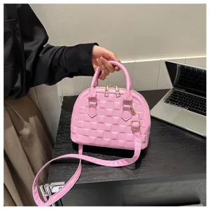 Detalle de bolso acolchado rosa con herrajes dorados en un escritorio de oficina