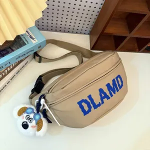Close-up of a khaki nylon waist bag featuring blue DLAMD print and a cute dog charm