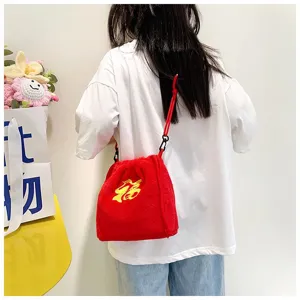 Back view of a child wearing a red plush drawstring bag with lucky character embroidery