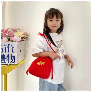 Cute young girl wearing a red plush drawstring blessing bag with gold embroidery detail