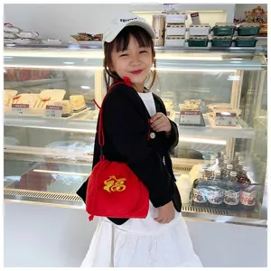 Cute red plush fortune bag with gold embroidery for girls, lifestyle shot in bakery setting