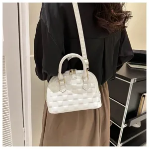 Vista posterior de modelo con un bolso de mano blanco acolchado con forma de concha.