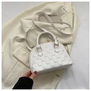 Vista detallada de un bolso blanco con textura de cuadros y herrajes dorados elegantes