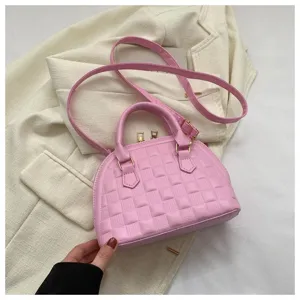 Vista detallada de un bolso rosa acolchado con elegantes detalles dorados
