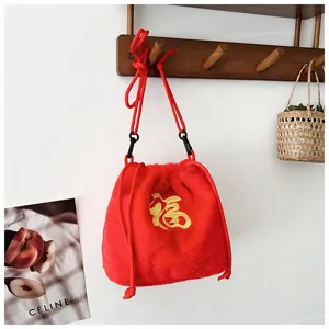 Detail view of cute red plush drawstring bag featuring golden Fu embroidery for kids