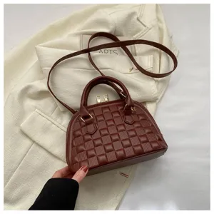 Detalle de bolso de mano acolchado marrón con cremalleras doradas elegantes.