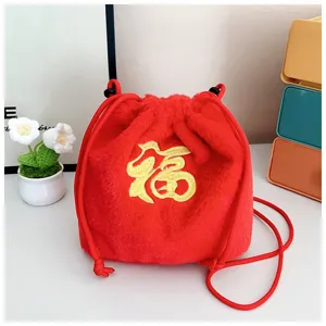 Macro view of red plush drawstring bucket bag with gold 'Fu' embroidery design