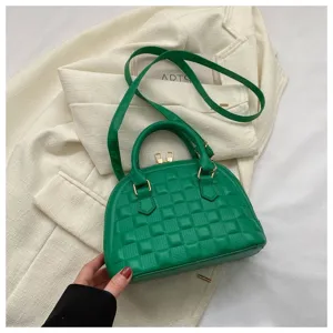 Bolso de mano verde vibrante con diseño de concha y detalles dorados en chaqueta