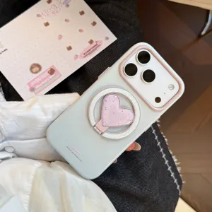Gros plan d'une coque iPhone vert menthe avec un support bague en forme de cœur rose brillant.