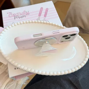 Side view of polka dot iPhone case with integrated magnetic stand on a white plate