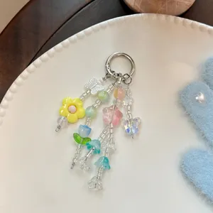 Detailed macro shot of a colorful beaded phone charm featuring flower and butterfly beads