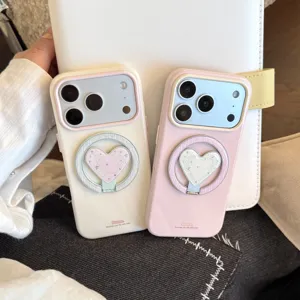 Détail du support de bague magnétique en forme de cœur sur coques de téléphone rose et crème