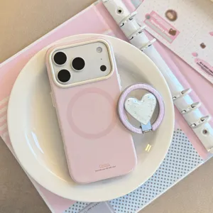 Coque MagSafe rose avec support cœur à paillettes sur une assiette décorative
