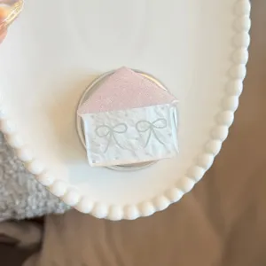 Detailed view of pink glitter house magnetic phone grip with blue bow patterns
