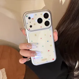Detailed view of a silver iPhone case featuring a colorful gilded star pattern held by a hand