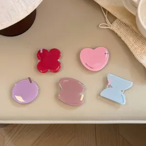 Vue détaillée de supports de téléphone géométriques en époxy coloré en forme de cœur et trèfle