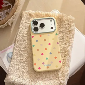Dettaglio della custodia per iPhone a pois macaron su sfondo in tessuto beige morbido.