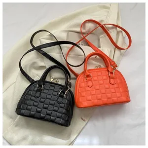 Primer plano de bolsos tipo concha con textura de cuadros en colores negro y naranja