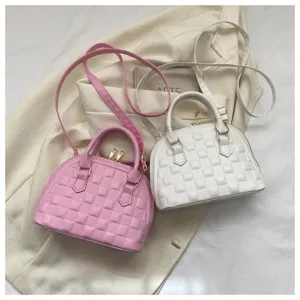 Detalle de la textura acolchada de los bolsos de mano rosa y blanco con herrajes dorados.