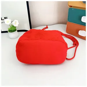 Close-up view of a cute red plush drawstring bag for girls with soft furry texture.