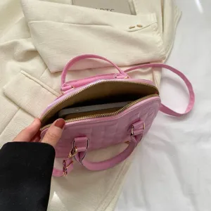 Detalle del interior de un bolso rosa acolchado que muestra el espacio para un teléfono