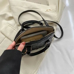 Vista interna de un bolso de mano acolchado negro con capacidad para teléfono y billetera