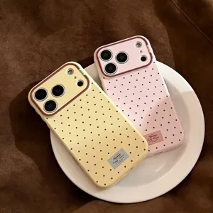 Gros plan sur la coque iPhone rétro à pois jaune et rose sur une assiette.