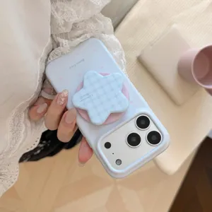 Détail d'une coque iPhone bleu clair à motifs d'étoiles avec un support de téléphone en étoile.