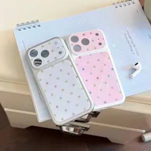 Vue détaillée des coques iPhone roses et argentées avec des pois strass colorés.