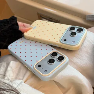 Vue rapprochée de coques iPhone à pois crème et bleu avec cadres de caméra contrastés