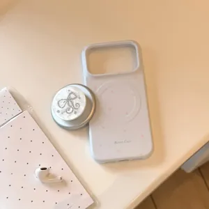Detail van wit iPhone-hoesje met roze sterren en parelmoeren strik magnetische grip