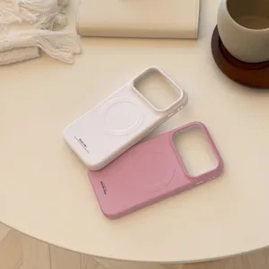 Détail des coques iPhone magnétiques mates en crème et rose sur une table