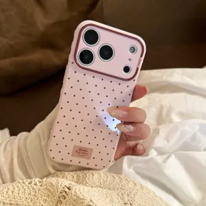 Détail d'une coque iPhone rose à pois avec un cadre de protection marron pour caméra