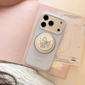 Detail van lichtblauwe iPhone-hoes met magnetische standaard met parelmoer strik.