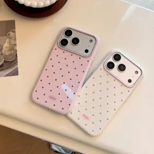 Vue détaillée de coques de protection pour iPhone à pois rose et crème sur table blanche