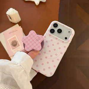 Gros plan sur une coque iPhone à pois roses et un support en forme d'étoile à carreaux.