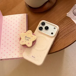 Vue détaillée d'une coque iPhone crème avec des taches roses et un support étoile.