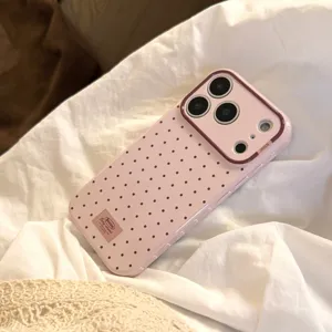 Vue détaillée d'une coque iPhone rose à pois avec un cadre de protection marron