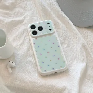 Vue détaillée de la coque iPhone blanche avec pois colorés scintillants sur vert pastel.