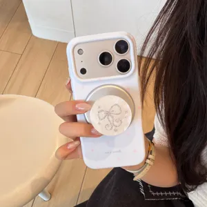 Detail van een witte iPhone-hoes met parelmoeren strik en magsafe-grip voor de telefoon