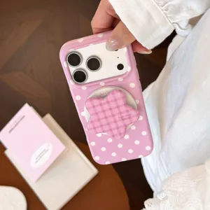 Gros plan d'une coque iPhone rose à pois avec un support magnétique en forme d'étoile