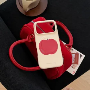 Gros plan sur une coque iPhone crème avec imprimé pomme rouge et texte estival.