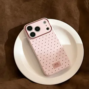 Vue détaillée d'une coque iPhone rose à pois sur une assiette décorative blanche