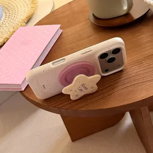 Gros plan d'une coque iPhone crème avec anneau magnétique rose et support étoile mignon
