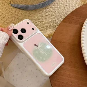 Close-up detail of a pink glitter iPhone case featuring a cute green apple and bow design.
